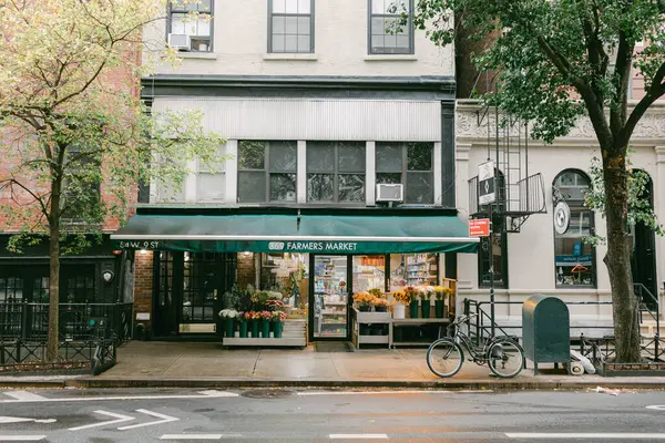 Samimi bir çiftçi marketinde taze çiçekler sergileniyor ve ağaçlarla kaplı canlı bir sokakta üretiliyor..