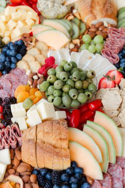 Etler, peynirler, meyveler ve fındıklar ahşap bir masaya serilmiştir. Eğlenmek için mükemmeldir..