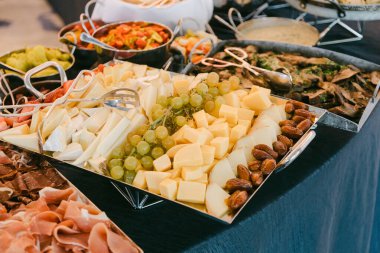 Renkli bir peynir, üzüm ve fındık karışımı bir tabakta arkadaşlarla gündelik bir kutlama düzenlenir..
