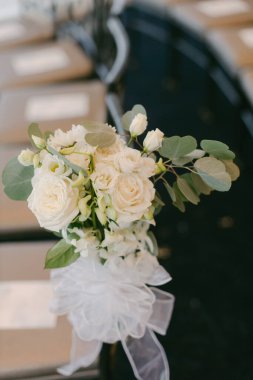Göz kamaştırıcı bir buket beyaz gül ve yeşillik zarif bir şekilde bir düğün yerinde sergileniyor..