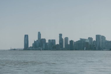 Gökdelenler suyun üzerinde görkemli bir şekilde yükselirler, güneşli bir günde çarpıcı bir şehir manzarası yaratırlar..