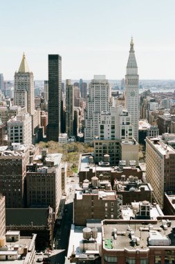 Gökdelenlerin ve şehir sokaklarının yukarıdan görünüşü berrak bir gökyüzünün altında hareketlilikle dolu..
