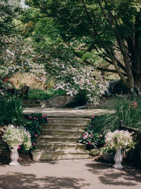 Canlı çiçekler ve yeşilliklerle çevrili büyüleyici bir patika ziyaretçileri sakin bahçeyi keşfetmeye davet ediyor..
