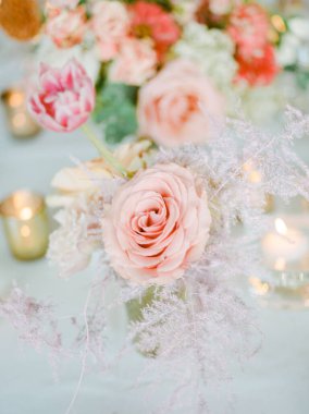 Hassas pastel güller ve laleler mumlar arasında ustalıkla düzenlenir. Huzurlu ve romantik bir ortam yaratırlar..