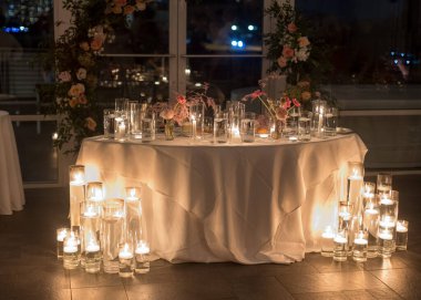 Romantik bir ortam için mumları ve çiçekleri olan güzel bir düğün masası..