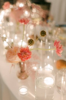 Çiçek ve mumların çarpıcı bir şekilde sergilenmesi akşam buluşmalarında atmosferi güçlendirir..