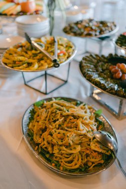Canlı bir açık büfe, bir kutlama sırasında renkli makarna ve sebzelerle Akdeniz yemekleri sergiler..
