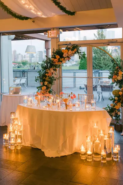 Çiçekler ve mumlarla dolu güzel bir masa kutlama için romantik bir ortam yaratır..