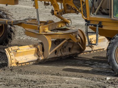 Grader Yolu İnşaat Grader Endüstriyel Makinesi yeni yollar yapıyor. Bir motorsikletlinin bıçağı kumlu bir yol temelini yıkıyor..