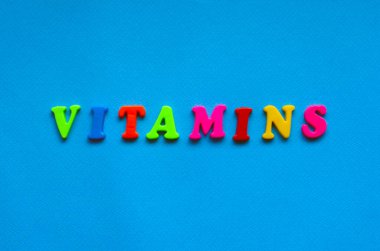 text vitaminsfrom plastic colored letters on blue paper background	