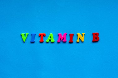 text vitamin  b from plastic colored letters on blue paper background