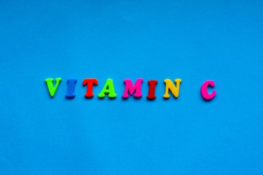 text vitamin c from plastic colored letters on blue paper background