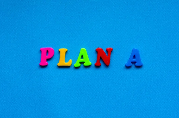 text plan a from plastic colored letters on blue paper background