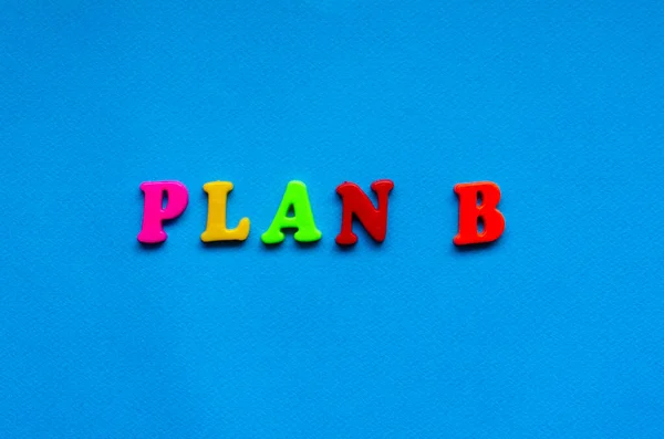 text plan b from plastic colored letters on blue paper background