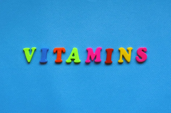 text vitaminsfrom plastic colored letters on blue paper background