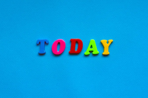 text today from plastic colored letters on blue paper background