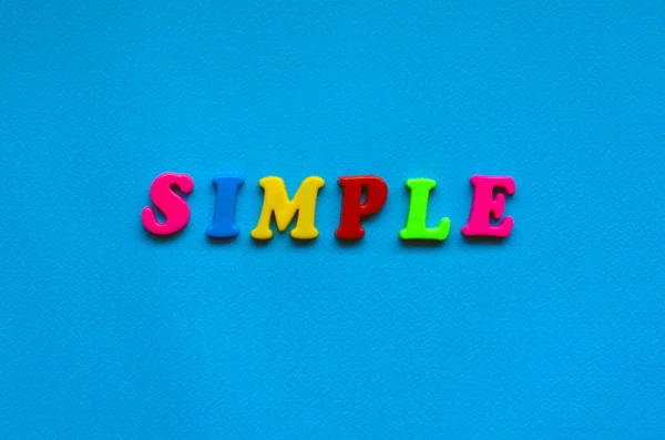 text simple from plastic colored letters on blue paper background
