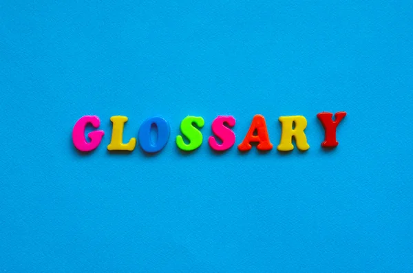 text glossary from plastic colored letters on blue paper background