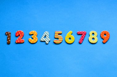 numbers from one to nine  one on blue paper background clipart