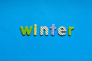 word winter on blue paper background