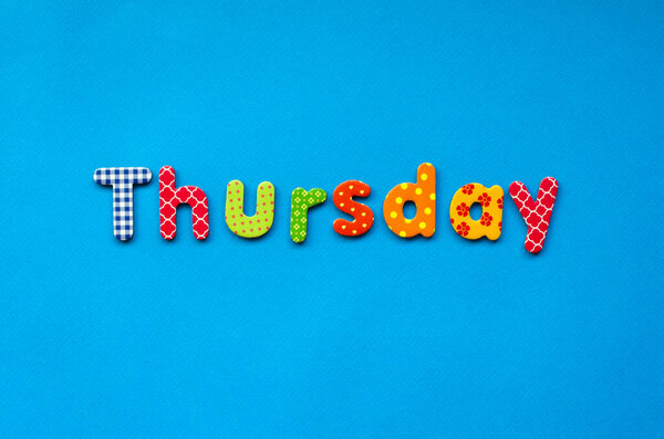 colored word Thursday on  blue paper background