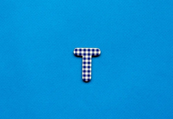 letter t on blue paper background