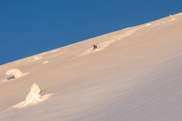 フリーライドゲレンデには緩んだ深い雪が積もりブレーキがかかっていました 新雪の中スキーで下り坂 空気中の雪の渦 — ストック写真