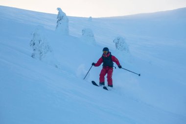 Kayakçı büyük dağlardaki serbest yamaçta eğildi. Kış açık hava konsepti