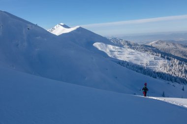 Kış gezisinde snowboard yürüyüşü yapan etkin bir kadın sürücü. Kış dağları dış mekan konsepti