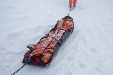 Dağ kurtarıcıları için özel bir kızak (akya) ortada kurban, bir adrenalin açık hava maceraları