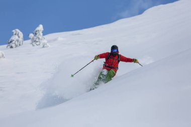 Yokuş aşağı yüksek bir yamaçta kayak yapmak kar püskürtmek, açık havada adrenalin salgılamak.