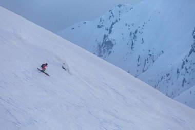 Bir kayakçı, kayalar ve ağaçlar arasında zorlu bir serbest güzergahtan iner. Adrenalin dolu bir açık hava macerası.