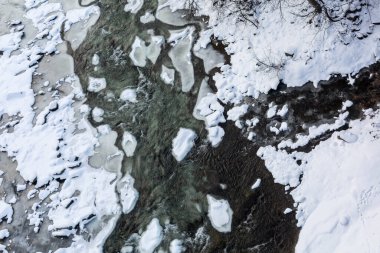 Karla kaplı donmuş bir nehirde buz oluşumları, üst manzara. Muhteşem kış manzarası.