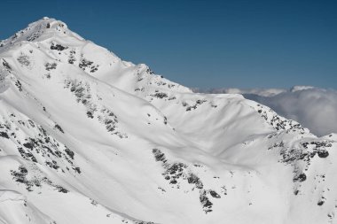 Kaltenbach Hochfugen, Austria - 9 Jan 2020: An old farmhouse under a large stone cliff