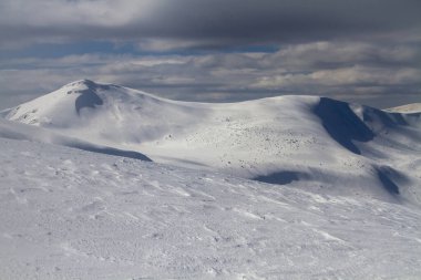 big white snow fields and blown snow in high alpine mountains