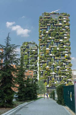 Yeşil cepheli ve yanında bitkiler olan bir bina. İtalya 'nın Milano şehrinde Bosco Verticale (Dikey Orman)