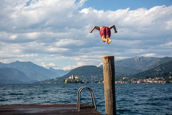 Een Man Springt Het Blauwe Water Van Het Meer Van — Stockfoto