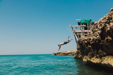 Mavi mayosuyla suya dalan bir adam. Denizde aşırı tatil