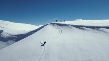 Karlı dağlarda snowboard yapmak. Kış serbest ekstrem sporları. Freeride, iki binici yokuş aşağı snowboard yapıyor.