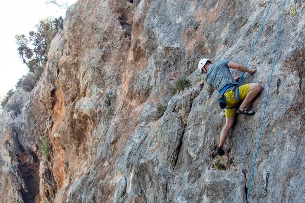 A climber conquers a challenging rock face with skill and determination.
