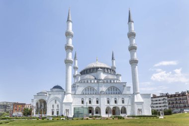 Ufuk çizgisine dört minaresi olan büyük beyaz cami, kemerli giriş ve güneş ışığında parlayan kubbeli çatı. Ankara, Türkiye