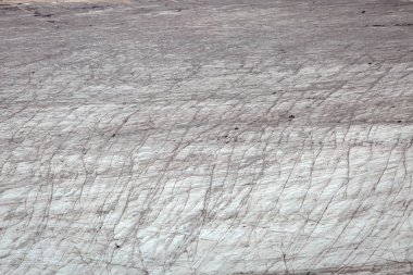 Buzulun buz oluşumları soyut heykellere benziyor. Uçsuz bucaksız bir buz tabakası uzanıyor, küçük figürlerle benekli, buzlu manzarayla gölgelenmiş..