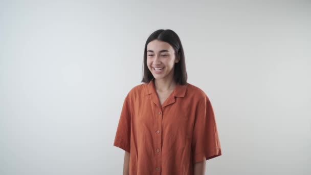 良いニュースのための喜びと勝利の若い女の子幸せなジェスチャー 彼女は素敵な笑顔で勝利に手を上げます オレンジオーカーシャツ — ストック動画