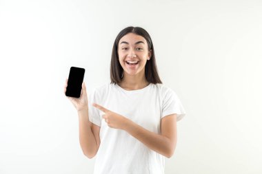 Genç kız mutlu bir gülümseme, iyi haberler veriyor ya da cep telefonundan mesaj yolluyor. Cep telefonundan alınan mesaj için sevinç ifadesi.