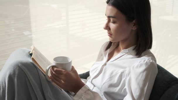 Entspanntes Mädchen Beim Lesen Eines Buches Mit Einem Kaffee Der — Stockvideo
