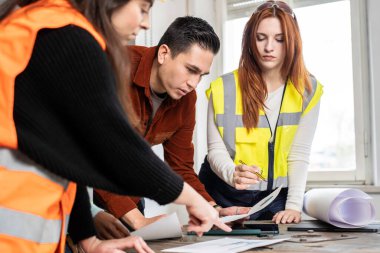 İnşaat alanında çalışan mühendis ve kadın çalışma ekibi inşaat alanında çalışma prensipleri belirliyor. Takım çalışması kavramı.