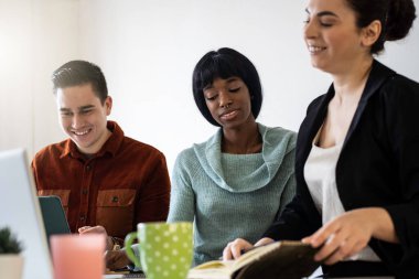 Modern ofiste çalışan çok ırklı iş adamları genç siyahi kadın yüzüne odaklanıyorlar.