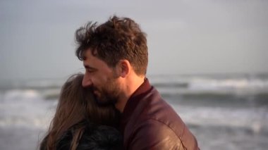 Güzel bir çift ilk buluşmada birbirlerine sarılıyor ve seviyorlar kız ve erkek, sonbahar sezonunda romantik kumsalda boş vakitlerin tadını çıkarıyorlar.