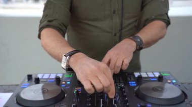 Portrait of disc jockey playing disco or deep music for people on beach party at sunset - Fun, and entertainment concept