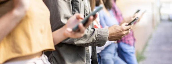 Üniversitenin arka bahçesinde oturan akıllı telefonları kullanan sıkıcı arkadaş grubuyla yatay afiş cep telefonu bağımlısı gençler her zaman bağlı öğrencilerle teknoloji üzgün yaşam konsepti